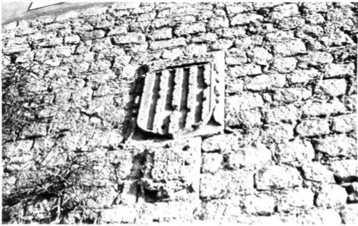 Detall d'una obertura amb reixa en un mur de la fortificació