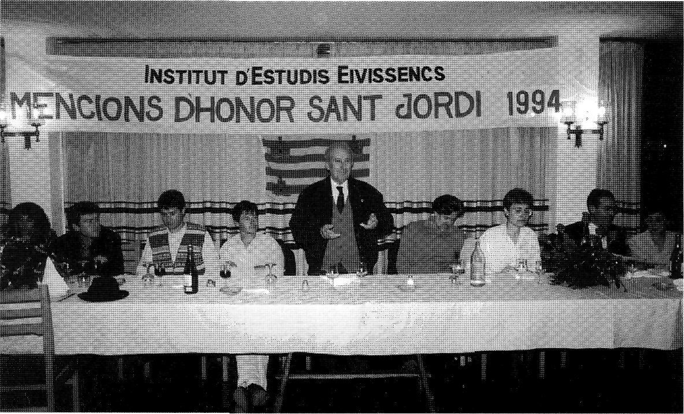 El president de l'I.E.E. fent l'oferiment de les Mencions. A l'esquerra els components del grup Aires Formenterencs, a la dreta Jean Serra.
