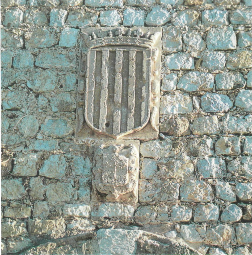 El nostre escut dels quatre pals i l'escut dels Sanoguera damunt les pedres del castell. (Foto: revista EIVISSA.)