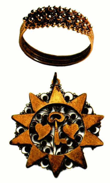 Una de las variants de la "fede" sarda que, com I™anell de borronat" d'Eivissa, és uns dels records típics d'aquella illa. "Pendente in lamina d'oro" amb la representació de dos cors i una clau, denominat "su sole" a Oliena (Nuoro). (Fotos: núm 583 de la Collezione Cocco, (www.collezionecocco.it) i www.sardiniashop.it).