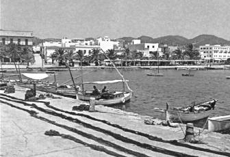 Pescadors i hotels conviuen al port de Sant Antoni de Portmany. A cada extrem de la foto es veuen dos dels hotels prototípics del turisme dels anys 30: a l'esquerra el Portmany i a la dreta, ja ampliat, el San Antonio