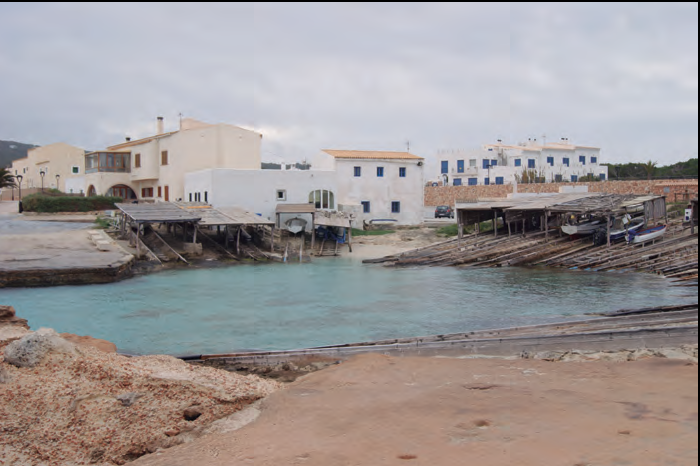A baix, l'arraval des Caló, a Formentera, vist des de la plaça del Delme, que es veu parcialment, en primer terme (foto: Laura Ribes Martínez).