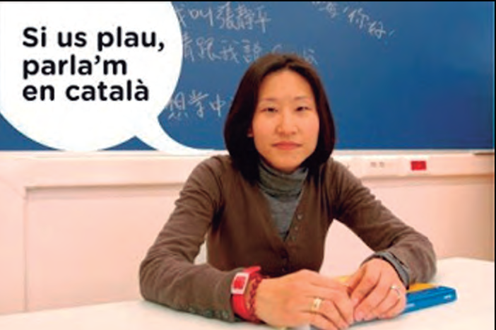 Dona asiàtica somrient amb el text 'Si us plau, parla'm en català'