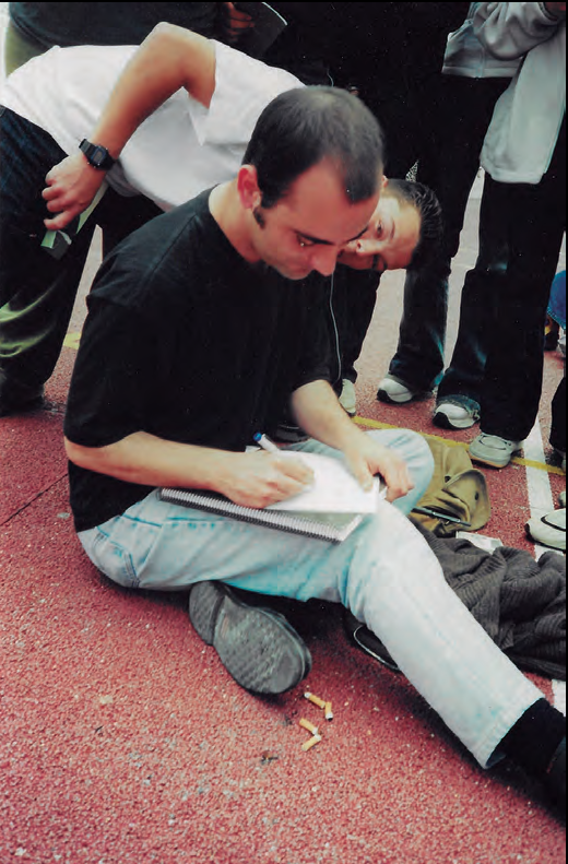 Manel Marí, en una xerrada amb estudiants, el 9 de maig del 2001, signant dedicatòries d'un dels seus poemaris (fotografia: Marià Torres i Torres)