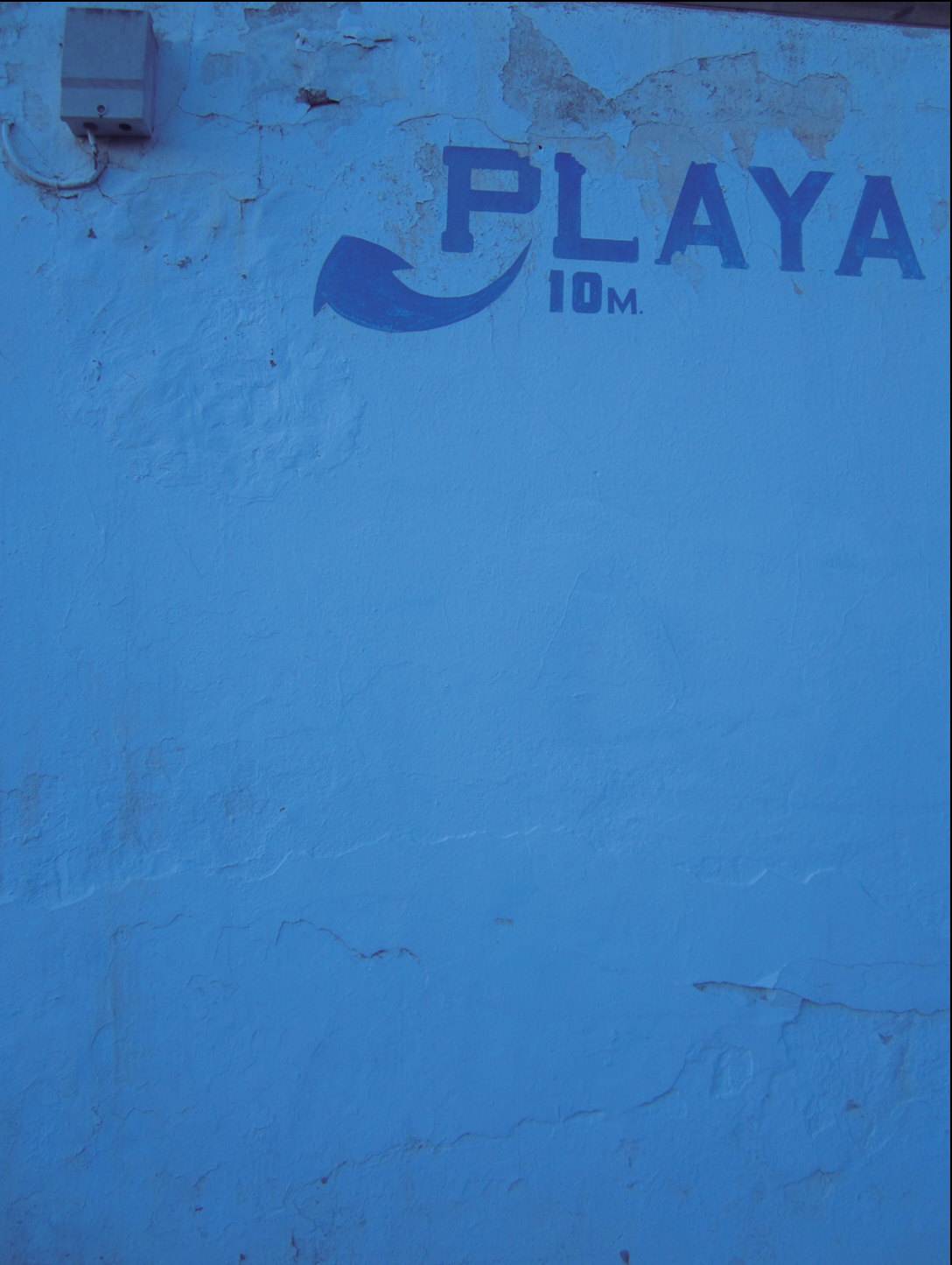 Paret blava amb rètol "PLAYA 10M"