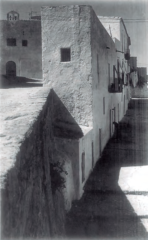 Carrer de la Conquesta (a la dreta) i de Joan Roman (a l'esquerra, abans de ses Monges). Al fons, el convent de ses Monges tancades. Final anys 20-principi anys 30 del segle XX. Fotografia: Domingo Viñets. Arxiu d'Imatge i So Municipal d'Eivissa (AISME).