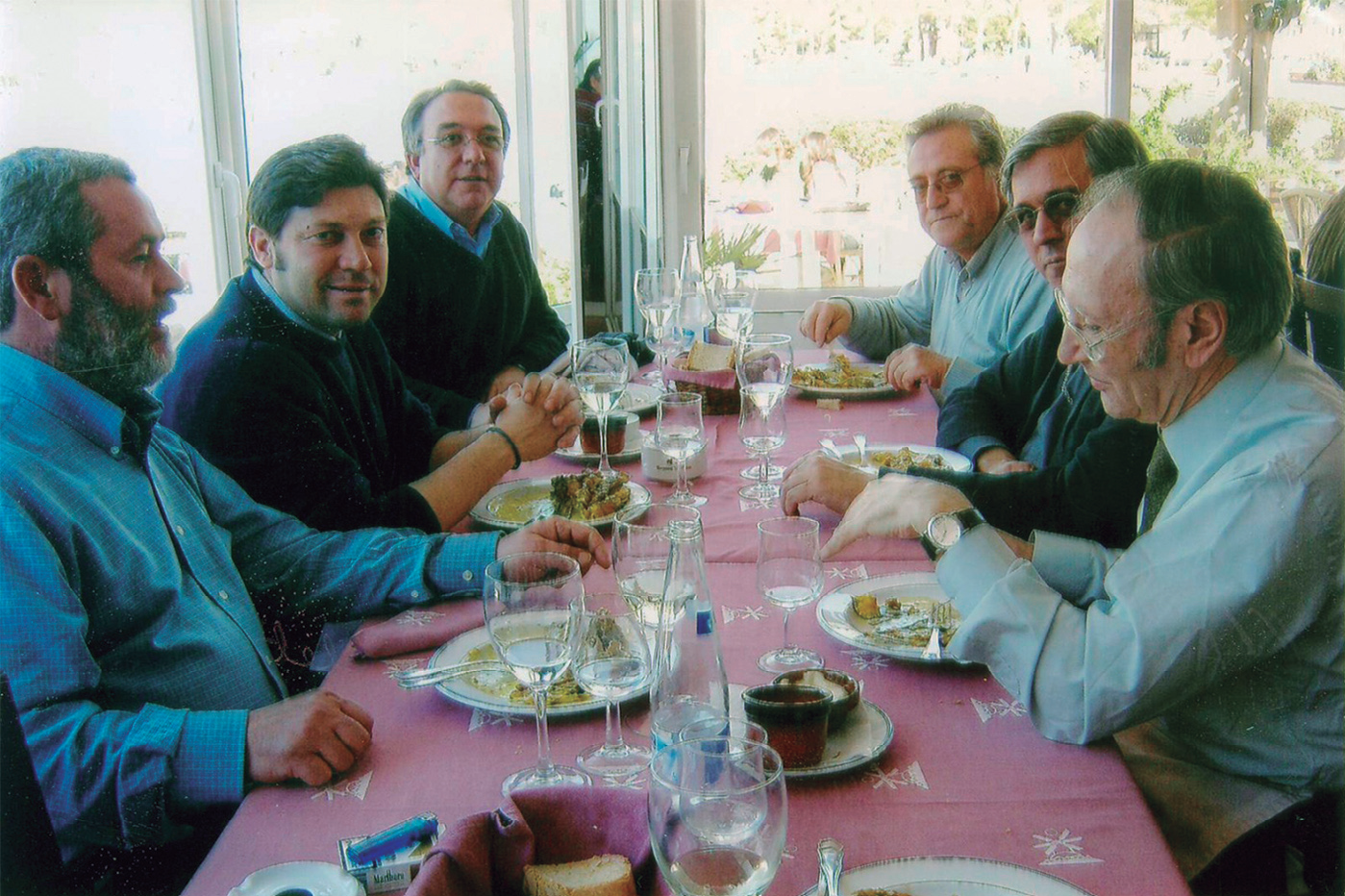 Any 2006. El pare Massot, l'abat Josep Maria Soler, Mn. Vicent Colomar “Pins”, Marià Torres, J. Esteve Costa i l'editor Miquel Costa, compartint un guisat de peix a Sant Antoni (fotografia: Lina Fiol).