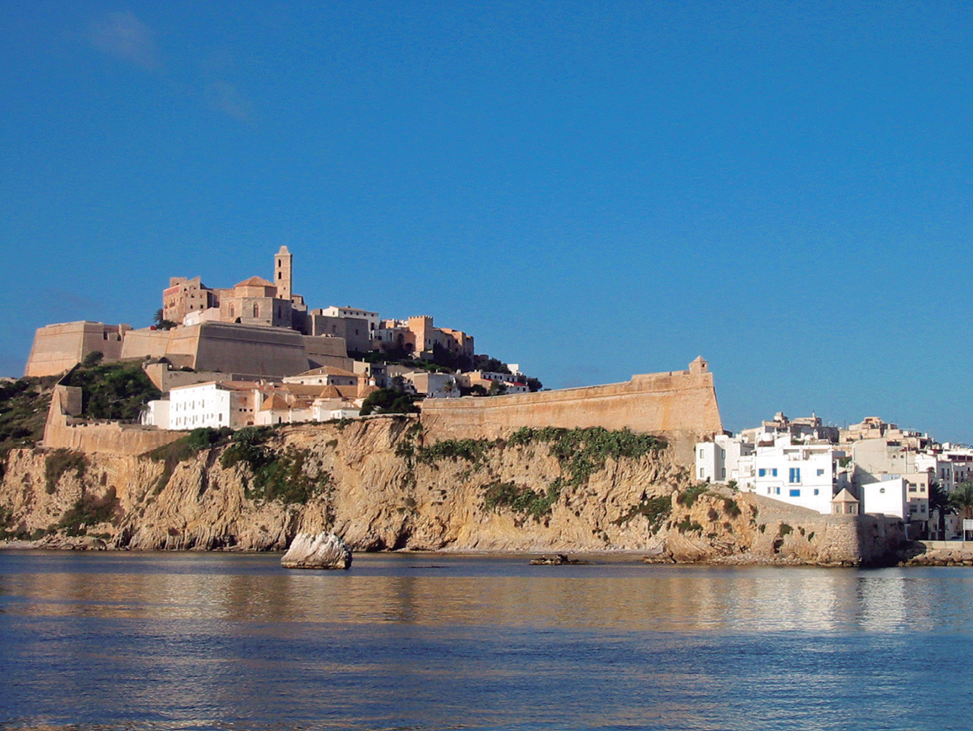 Vista del nucli antic d'Eivissa, Dalt Vila, des del mar, amb la catedral a la part superior i les muralles que envolten els edificis blancs.