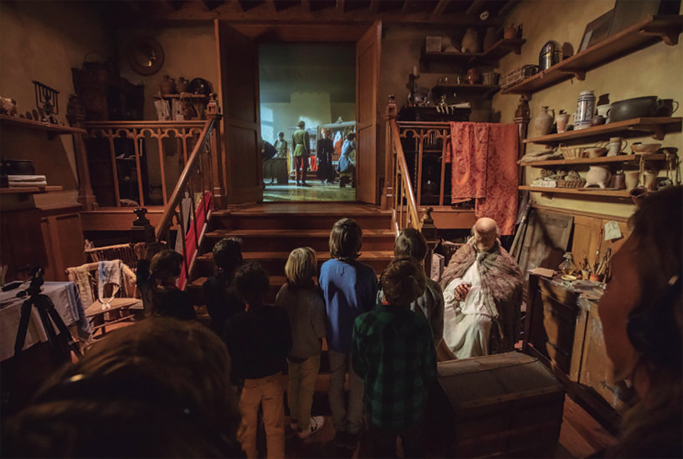 Nens interactuant amb una porta dins d'un museu, part d'una experiència immersiva.