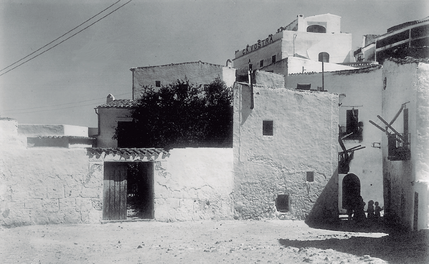 Fotografia en blanc i negre d'una plaça amb edificis de pedra blanca