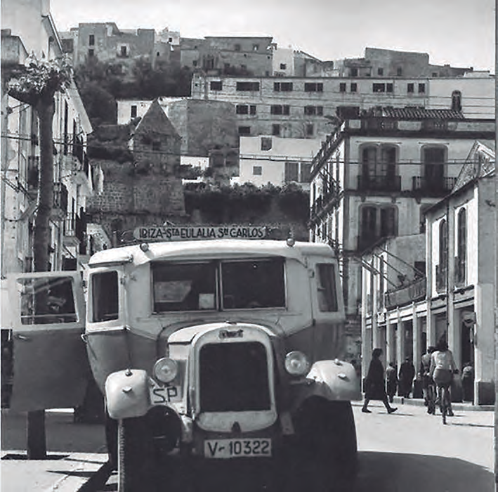 Un camió antic, model V-10322, aturat en un carrer d'un poble.