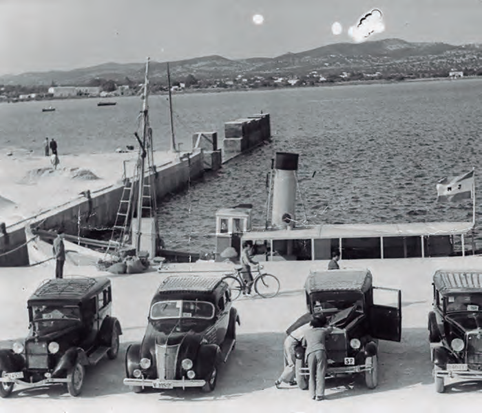 Cotxes antics i un vaixell atracat al port d'Eivissa.